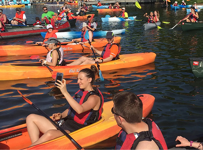 Large group of people stitting on kayaks