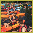 Large group of people stitting on kayaks
