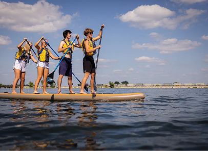 Group of 4 paddling while standing on a paddle board