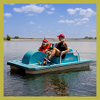 Man and monkey stuffed animal on paddle boat on the lake